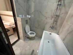 a bathroom with a shower and a toilet and a tub at villacaptaingomi in Gomi +15 photos