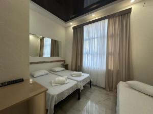 a hotel room with two beds and a mirror at villacaptaingomi in Gomi