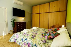 a bedroom with a bed with a floral bedspread at Camera Verde vicino alle Mura - Madame Fannj in Lucca