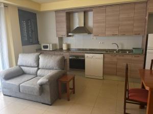 een woonkamer met een bank en een keuken bij Apartamento Céntrico in Amposta