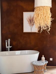 a bathroom with a white tub and a picture at Radawa LOVE in Radawa