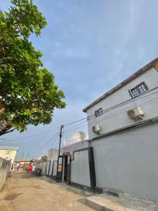 ein weißes Gebäude am Straßenrand in der Unterkunft Le Centurion in Brazzaville + 6 Fotos