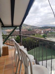 a balcony with white chairs and a view at La tranquera hotel in Villa de Leyva