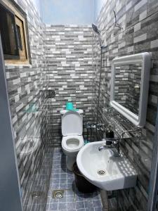 ein Badezimmer mit weißer Toilette und Waschbecken in der Unterkunft Le Centurion in Brazzaville