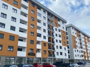 een appartementencomplex met auto's geparkeerd op een parkeerplaats bij FILIP Lux Apartman sa garažom in Doboj