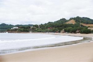 a beach with a group of people walking on the sand at EL TUMBO in El Gigante