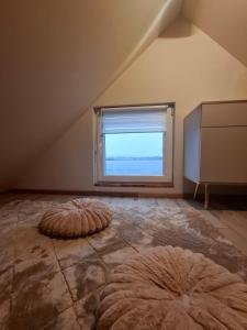 an attic room with a large window and a large rug at Wilczy Domek nad Witką in Wilka