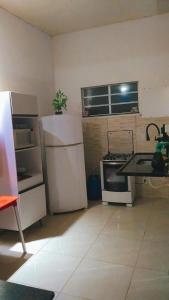 a kitchen with a white refrigerator and a stove at Hostel Mariah in Cabo Frio +14 photos