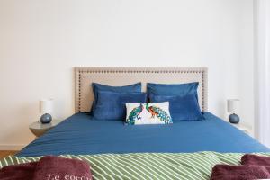 a bed with blue sheets and blue pillows at Rodern - Le Cocon des vignes in Rodern +41 photos