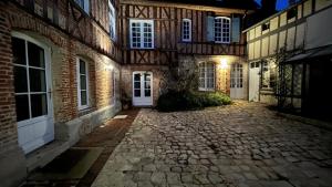 un cortile vuoto di un edificio in mattoni di notte di Le Logis de Pélagie a Neufchâtel-en-Bray