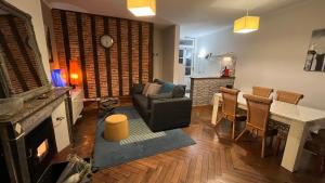 un soggiorno con tavolo, sedia e divano di Le Logis de Pélagie a Neufchâtel-en-Bray