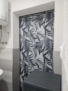 a bathroom with a shower with a black and white wallpaper at Apartmani Planinsko srce Vlašić in Vlasic +9 photos