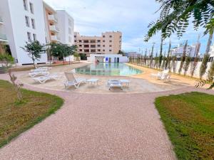 a swimming pool with lounge chairs in a building at Great Holiday suites in Agadir