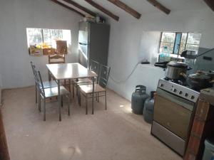 a kitchen with a table and chairs and a stove at Refugio tierra viva in Cusco