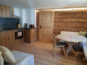 a kitchen with a table and a wooden floor at Ferienwohnung Schwalbennest in Hopfgarten im Brixental +6 photos