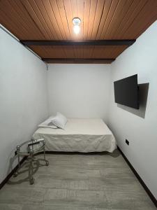 een slaapkamer met een bed en een tv aan de muur bij Nat!va 301 in Cali