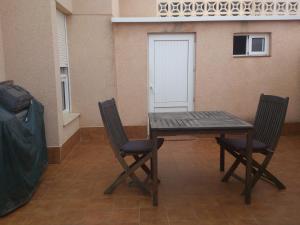 a wooden table and two chairs in a room at Pareado Cabo de Palos in Cabo de Palos