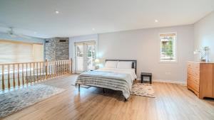 a bedroom with a bed and a wooden floor at Muskoka 4-Bedroom Cottage in Port Carling