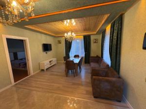 a living room with a dining room table and chairs at Villa Qecres in Küpçal
