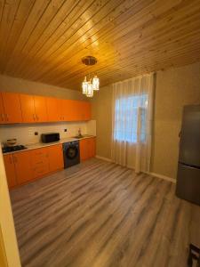 a kitchen with orange cabinets and a wooden ceiling at Villa Qecres in Küpçal