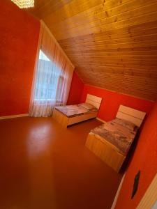 an attic room with two beds and a window at Villa Qecres in Küpçal