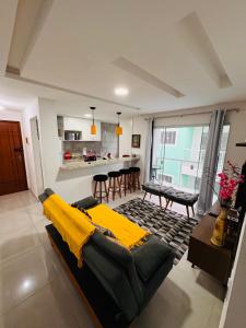 een woonkamer met een bank en een eetkamer bij Ap 800m da praia in Rio das Ostras