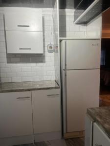 a kitchen with white cabinets and a refrigerator at Oryx guest house in Oakdale +17 photos