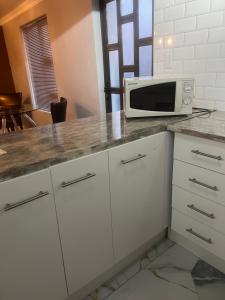 a kitchen with a white counter top with a microwave at Oryx guest house in Oakdale