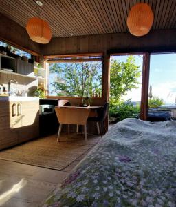 a bedroom with a desk and a kitchen with a large window at FjordView Sanctuary in Nedstrand