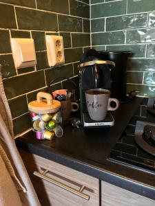 a counter with a coffee maker and a cup on it at Beachhouse Noteboom, omheinde tuin in Noordwijk aan Zee
