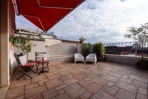 eine Terrasse mit Stühlen, einem Tisch und einem Sonnenschirm in der Unterkunft Malìa Home in Catania