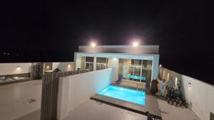 a house with a swimming pool at night at sun in Būbādī +8 photos