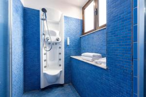 ein blaues Bad mit einer Dusche und einem Waschbecken in der Unterkunft Malìa Home in Catania