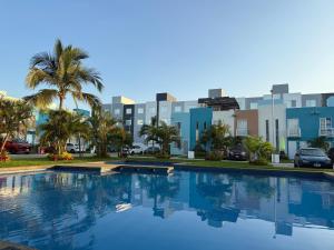 a large swimming pool in front of a city at Tu hogar en acapulco in General Juan N Alvarez International Airport