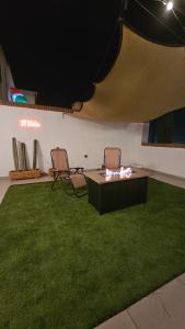 a room with two chairs and a table and grass at Terraza y Fire pit con vista increíble in Chihuahua