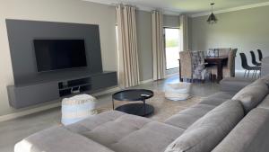 un soggiorno con divano e TV a schermo piatto di CELONIA VILLA Euphoria 442 a Mookgophong