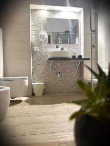 a bathroom with a sink and a toilet and a mirror at Marselo B&B in Bari