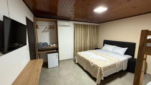 a bedroom with a bed and a flat screen tv at El Rodeo Hospedaje in Encarnación