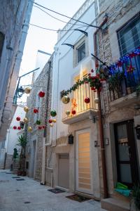 een smal steegje met gebouwen versierd met bloemen en decoraties bij La Maddalena 5 in Bitetto