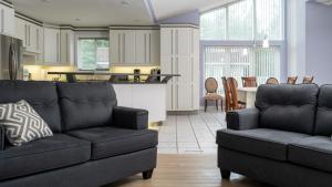 a living room with two couches and a kitchen at Muskoka 4-Bedroom Cottage in Port Carling