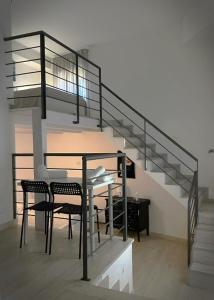 a staircase with a table and chairs in a room at Marselo B&B in Bari