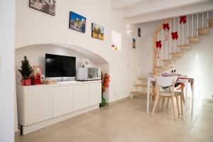 een woonkamer met een televisie en een tafel met stoelen bij La Maddalena 5 in Bitetto