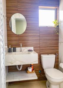 a bathroom with a sink and a mirror and a toilet at Flat Morada da Neblina! in Chapada dos Guimarães