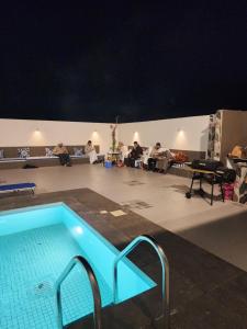 a swimming pool in a room with a group of people at Sun & moon in Būbādī
