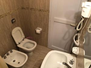 a small bathroom with a toilet and a sink at Calafquén in San Antonio Este +3 photos