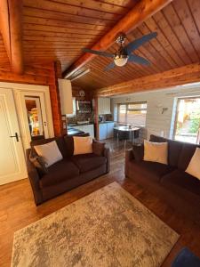 a living room with two couches and a ceiling fan at Home From Home LogCabin in Trawsfynydd
