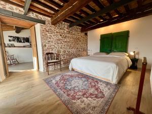 una camera da letto con un letto e un muro di mattoni di Casa Betta - A 700 Year Old Tuscan Gem a Chiusdino