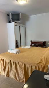 a room with two beds and a tv on the wall at Calafquén in San Antonio Este
