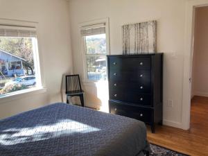 ein Schlafzimmer mit einem Bett, einer Kommode und einem Fenster in der Unterkunft The Jackson House in Jackson