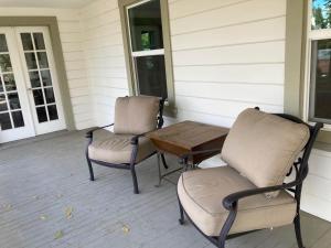 zwei Stühle und ein Tisch auf einer Veranda in der Unterkunft The Jackson House in Jackson